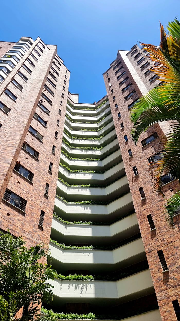 Low angle view of a modern high-rise building with glass and brick facade in Bucaramanga, Colombia.
