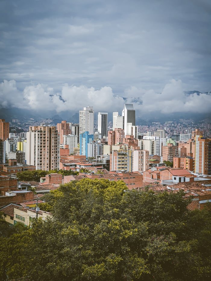 A panoramic view of Medellín's skyline featuring the iconic Coltejer Building and lush greenery.